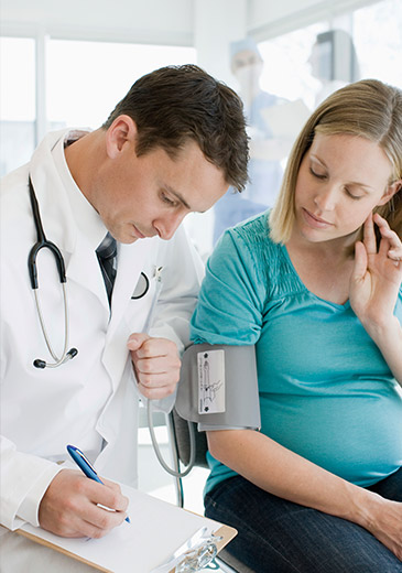 Arzt misst Blutdruck bei schwangerer Frau (Foto)