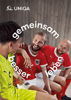 Drei Fußballspieler lächeln und unterhalten sich.